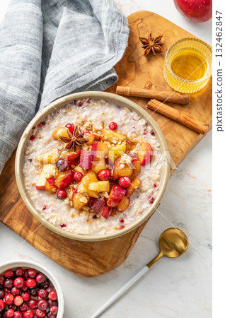 Overnight oatmeal with apple, honey, cranberry and cinnamon in a plate on a marble background Overnight oatmeal with apple, honey, cranberry and cinnamon in a plate on a marble background 132462847