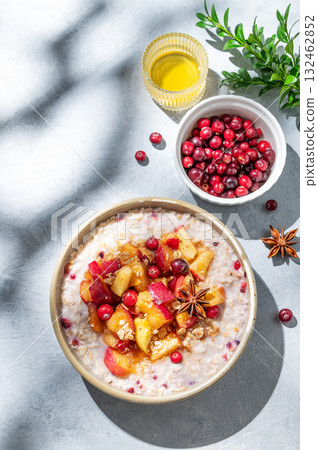 Overnight oatmeal with apple, cranberry, honey and cinnamon in a bowl on a blue background 132462852