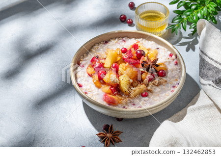 Overnight oatmeal with apple, cranberry, honey and cinnamon in a bowl on a blue background Overnight oatmeal with apple, cranberry, honey and cinnamon in a bowl on a blue background 132462853