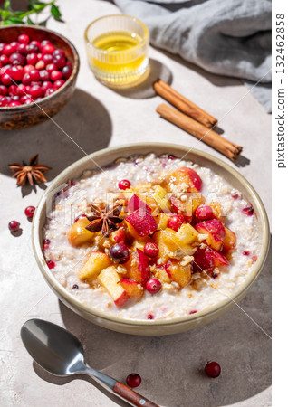 Overnight oatmeal with apple, cranberry, honey and cinnamon in a plate on a light background 132462858