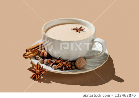 Traditional Indian masala chai tea with milk and spices in a cup on a beige background 132462870