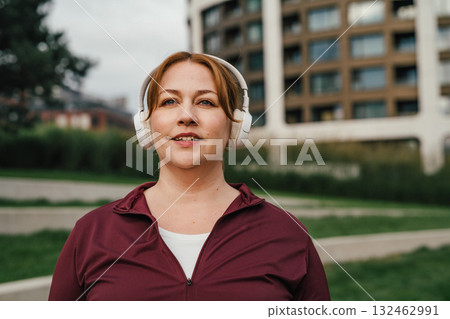 Body positive woman listening music during sport training. 132462991