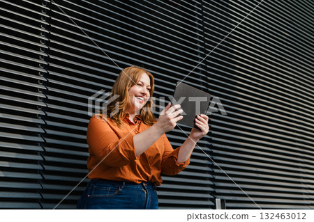 Plus size woman holding tablet, black background. Plus size woman holding tablet, black background. 132463012
