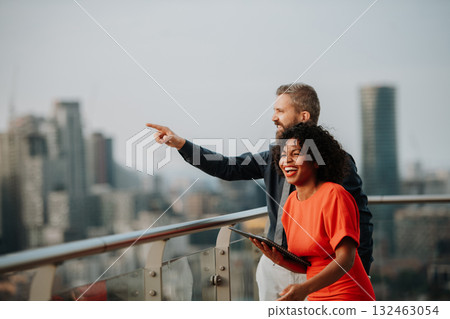 Real estate agent talking to client on the rooftop of a modern building 132463054