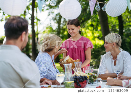Family sharing food during garden grill party. Family sharing food during garden grill party. 132463099