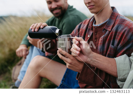 Grandfather, father and teen boy hiking togeter in nature, having cup of tea. Grandfather, father and teen boy hiking togeter in nature, having cup of tea. 132463113