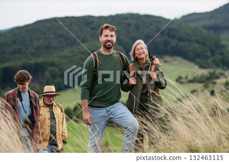 Mature son walking by senior mom during family hiking trip. 132463115