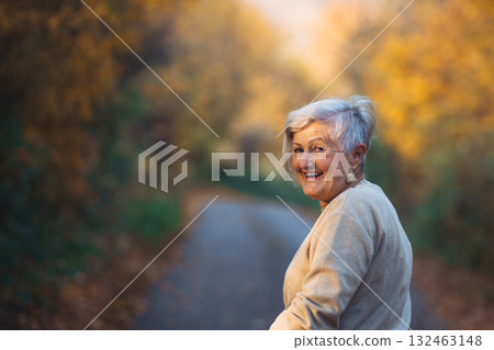 Senior woman walking outdoors in autumn forest. Senior woman walking outdoors in autumn forest. 132463148