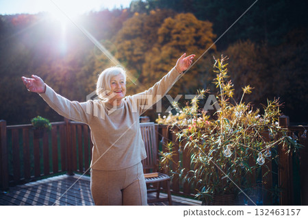 Senior woman enjoying warm autumn sun. Senior woman enjoying warm autumn sun. 132463157