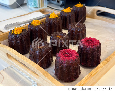 Canele pastries with colorful decoration. French dessert, baking mastery and texture contrast in confectionery art. Canele pastries with colorful decoration. French dessert, baking mastery and texture contrast in confectionery art. 132463417