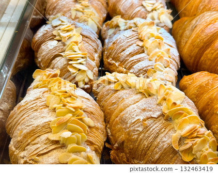 Almond croissants on bakery shelf. Sweet pastry, French tradition, and indulgent breakfast experience. Almond croissants on bakery shelf. Sweet pastry, French tradition, and indulgent breakfast experience. 132463419
