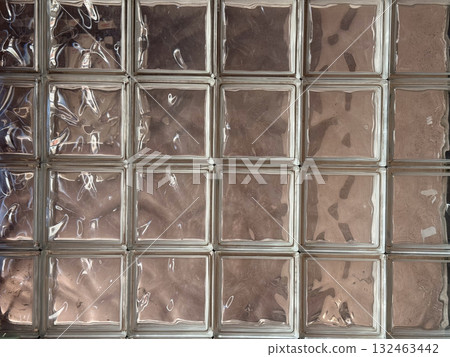 Pattern of glass blocks with reflective surface and textured transparency. Architectural design, geometric repetition and light abstraction in modern interior. 132463442