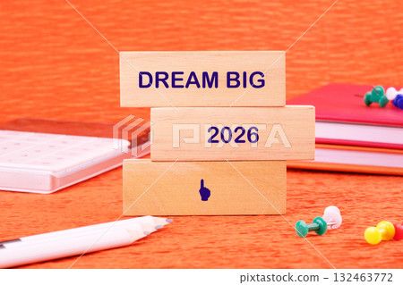 Colorful wooden blocks display the words dream big and the year 2026 against a bright orange backdrop Colorful wooden blocks display the words dream big and the year 2026 against a bright orange backdrop 132463772