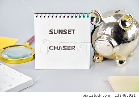 A notebook titled Sunset Chaser rests beside a shiny piggy bank, a magnifying glass, and colorful notes, representing creativity and the joy of capturing special moments A notebook titled Sunset Chaser rests beside a shiny piggy bank, a magnifying glass, and colorful notes, representing creativity and the joy of capturing special moments 132463921