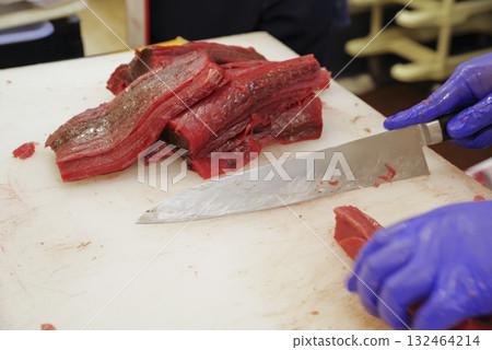A craftsman cutting the bloody part of a tuna at a cutting show A craftsman cutting the bloody part of a tuna at a cutting show 132464214
