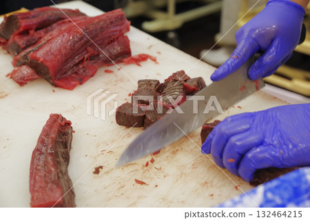A craftsman cutting the bloody part of a tuna at a cutting show A craftsman cutting the bloody part of a tuna at a cutting show 132464215