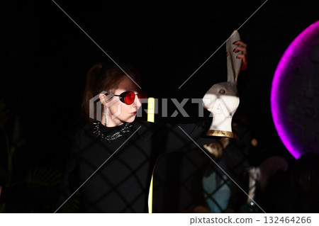 futuristic fashion scene, woman stands beside mannequin under neon lights in avantgarde setting futuristic fashion scene, woman stands beside mannequin under neon lights in avantgarde setting 132464266