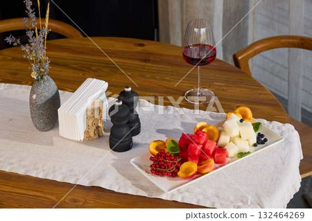 An Elegant and Colorful Fruit Platter Accompanied by Fine Wine on a Beautiful Wooden Table An Elegant and Colorful Fruit Platter Accompanied by Fine Wine on a Beautiful Wooden Table 132464269