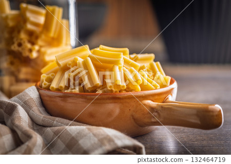 Cinque buchi. Uncooked italian pasta in bowl on wooden table. 132464719