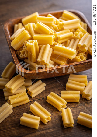 Cinque buchi. Uncooked italian pasta in bowl on wooden table. Cinque buchi. Uncooked italian pasta in bowl on wooden table. 132464721