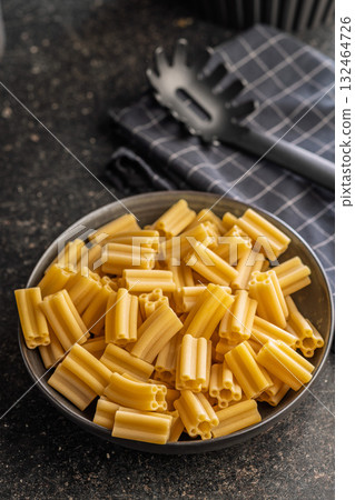 Cinque buchi. Uncooked italian pasta in bowl on black table. Cinque buchi. Uncooked italian pasta in bowl on black table. 132464726