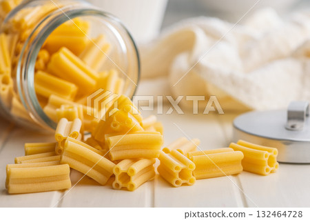Cinque buchi. Uncooked italian pasta in jar on white table. 132464728