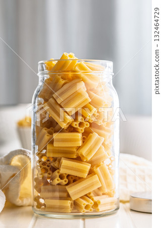 Cinque buchi. Uncooked italian pasta in jar on white table. Cinque buchi. Uncooked italian pasta in jar on white table. 132464729