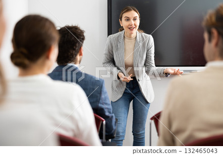 Young female professor explaining subject to classroom full of students 132465043