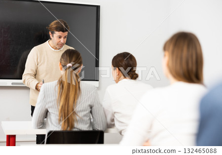 Knowledgeable professor explaining subject to classroom full of students Knowledgeable professor explaining subject to classroom full of students 132465088