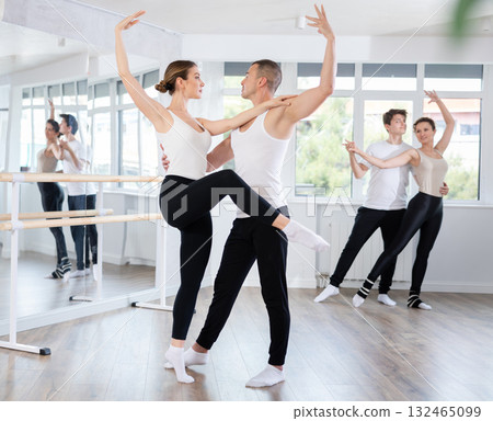 Graceful couple of ballet dancers performing supports at group class 132465099