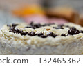 Close-up of a creamy dessert roll topped with chocolate chips. Delicious sweet pastry with soft texture and blurred colorful background, perfect for bakery, confectionery, or food photography 132465362
