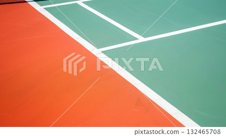 Empty outdoor paddle tennis court showing green and orange surfaces Empty outdoor paddle tennis court showing green and orange surfaces 132465708