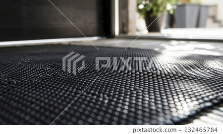 Black plastic doormat protecting home from dirt and debris 132465784