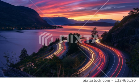 As the sun sets on the horizon the roads along the lake become a canvas for swirling car light trails 132466150