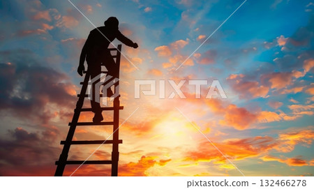 The silhouette of a construction worker seems to be stretching out in triumph as he climbs a ladder against a scenic sunset backdrop 132466278