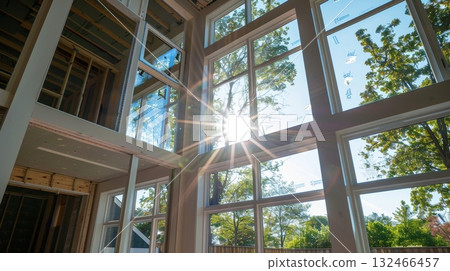 A series of large windows being installed strategically p to maximize natural light and reduce the need for artificial lighting A series of large windows being installed strategically p to maximize natural light and reduce the need for artificial lighting 132466457