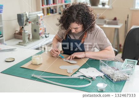 Woman tanner at work in the workshop. Woman tanner at work in the workshop. 132467333