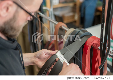 Caucasian bearded man working as a tanner in a workshop. Caucasian bearded man working as a tanner in a workshop. 132467377