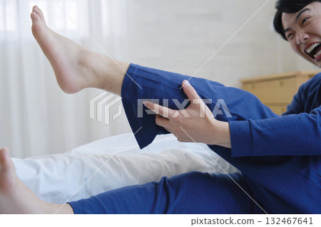 A man in his 20s with leg cramps in bed 132467641