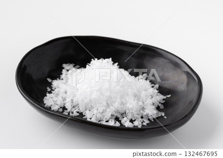 Coarse salt in a small dish on a white background Coarse salt in a small dish on a white background 132467695