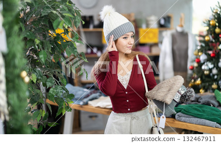 Girl try on head cover hat in front of mirror in clothes store. Girl try on head cover hat in front of mirror in clothes store. 132467911