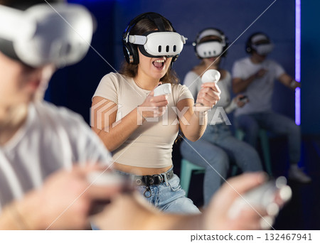 Girl in vr glasses with joysticks playing a video game 132467941