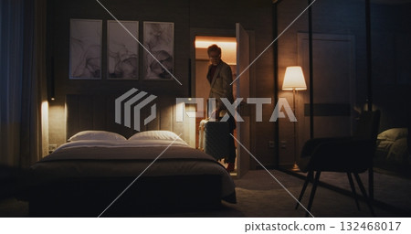 Tired Man Checks Into Cozy Hotel Room at Night 132468017