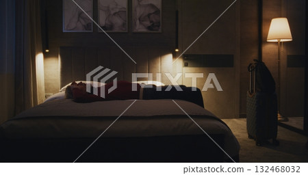 Tired Man Checks Into Cozy Hotel Room at Night 132468032