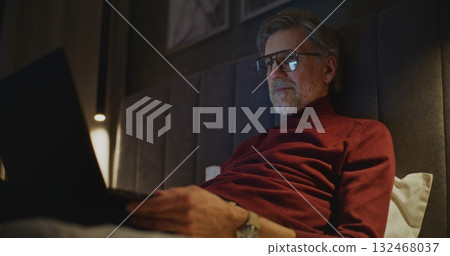 Aged Businessman Works on Laptop in Stylish Hotel Room Aged Businessman Works on Laptop in Stylish Hotel Room 132468037