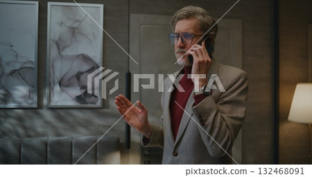 Elegant Businessman Enters Bright Hotel Room With Luggage Elegant Businessman Enters Bright Hotel Room With Luggage 132468091