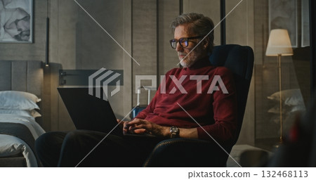Professional, Handsome Man Works Late Into Night in Modern Hotel, Illuminated by Lamp Professional, Handsome Man Works Late Into Night in Modern Hotel, Illuminated by Lamp 132468113
