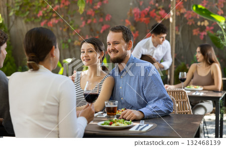 Couples of women and men eating and talking in restaurant Couples of women and men eating and talking in restaurant 132468139
