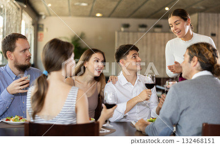 Female waitress taking order from group of friends in restaurant Female waitress taking order from group of friends in restaurant 132468151