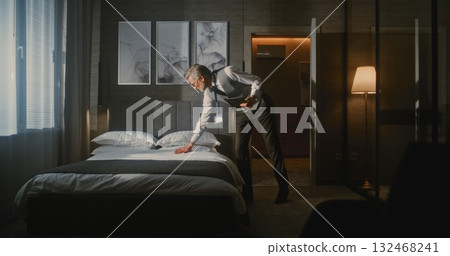 Elegant Mature Hotel Manager in Formal Suit Inspects Luxury Hotel Room 132468241